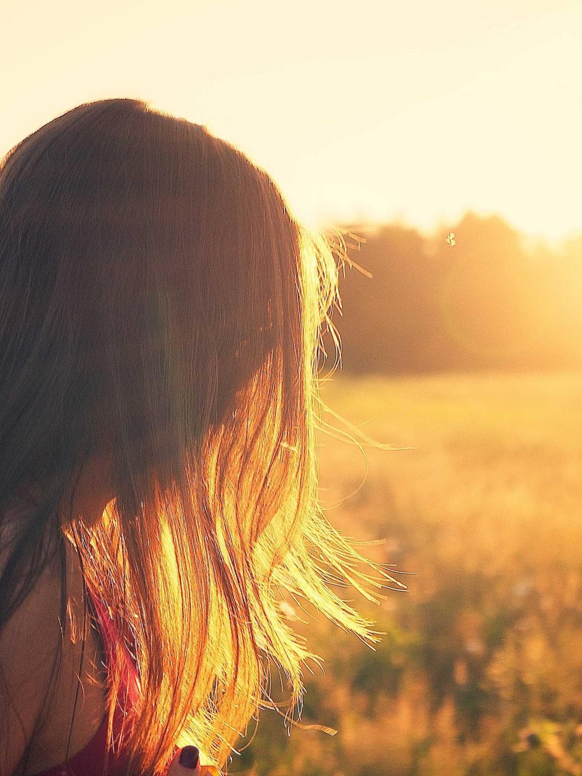 Person standing in a sunlit meadow at golden hour