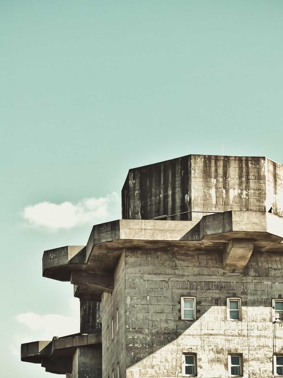 Brutalist concrete tower against a pale sky